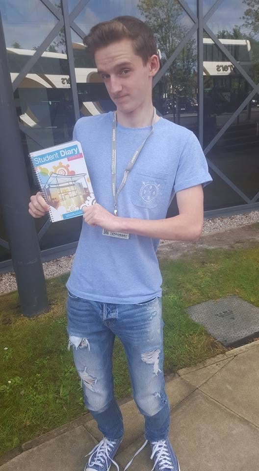 Brandon on his first day at college, holding his student diary